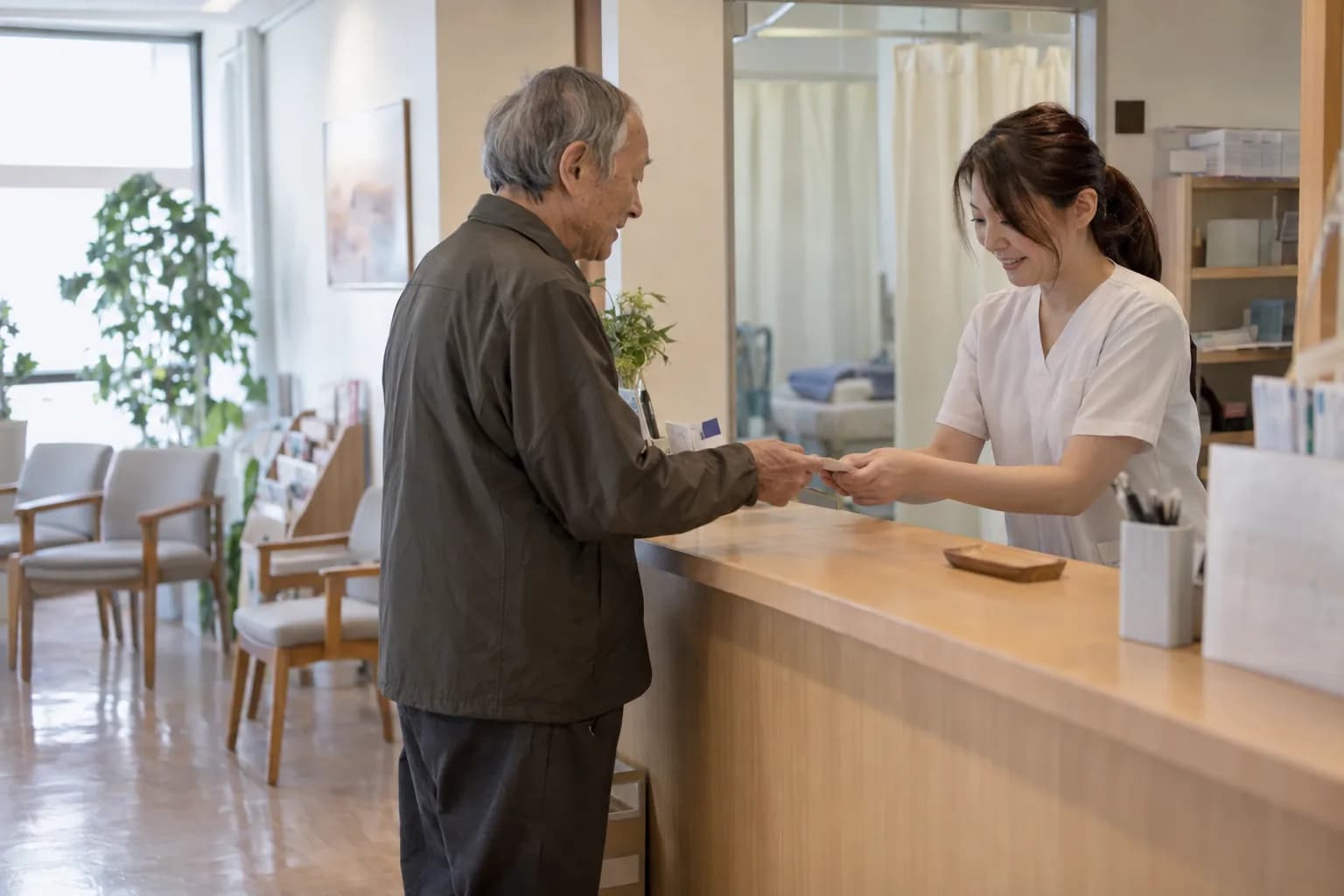 整骨院の受付で患者さんに対応するスタッフ