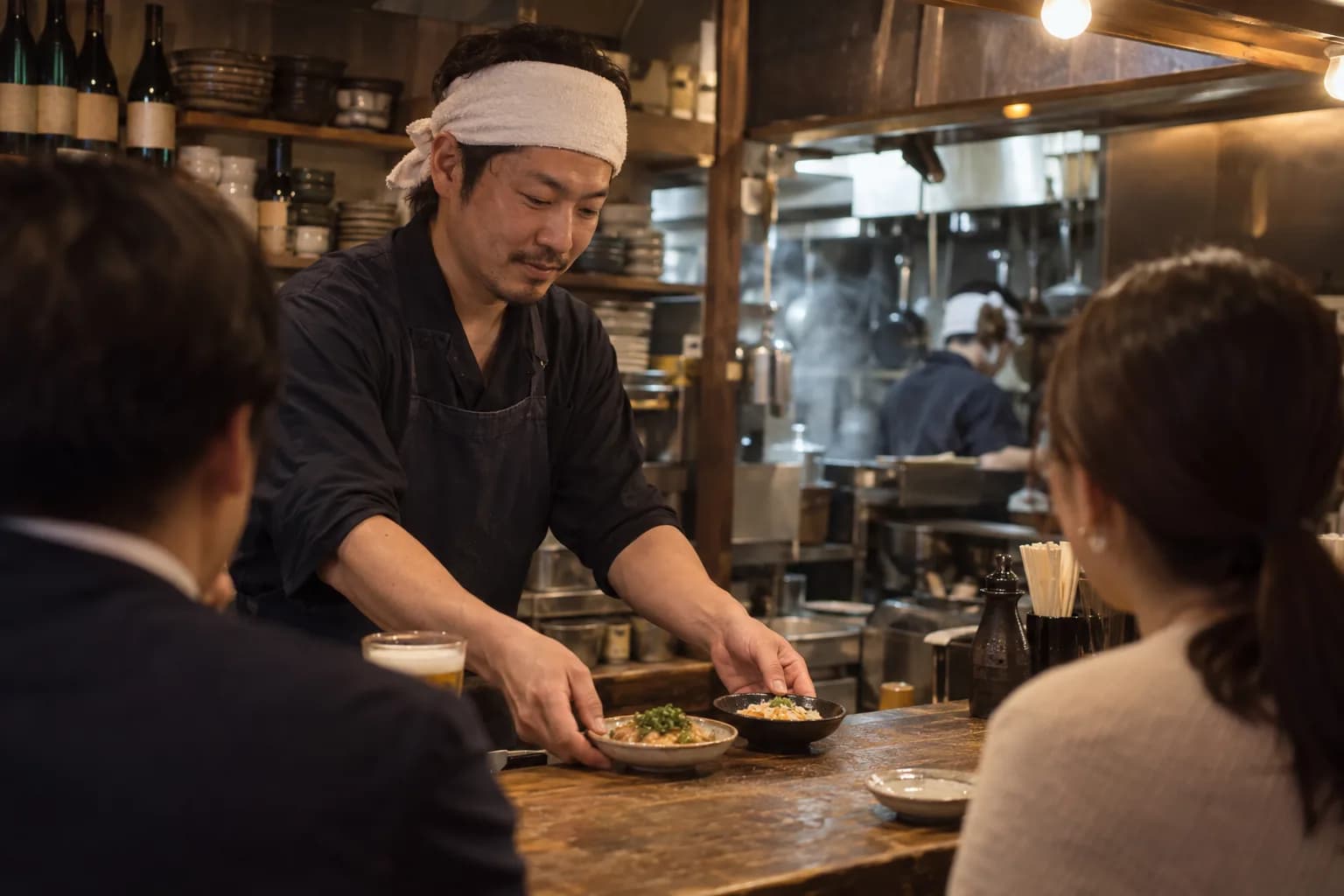 カウンター越しに料理を出す飲食店の店主